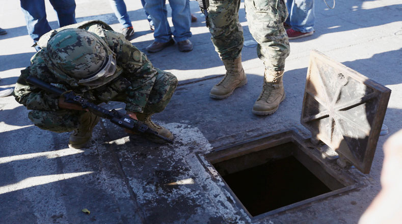 Un soldado apunta al lado exterior adonde conecta el túnel de "El Chapo".