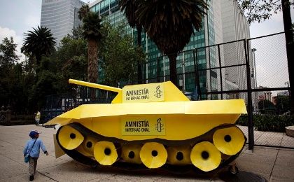 A child walks around a fake tank parked outside the US embassy during a protest held by Amnesty International in Mexico City..