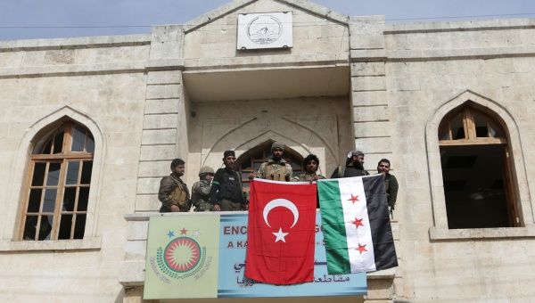 Members of Turkish forces and Free Syrian Army pose with their flags as they are deployed in Afrin, Syria March 18,2018.