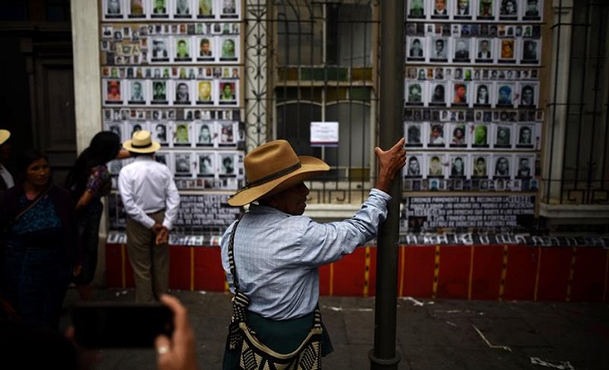 A man sees the pictures of about 40,000 people that went missing during the Guatemalan civil war. House of Memory, Guatemala City, May 10, 2018.