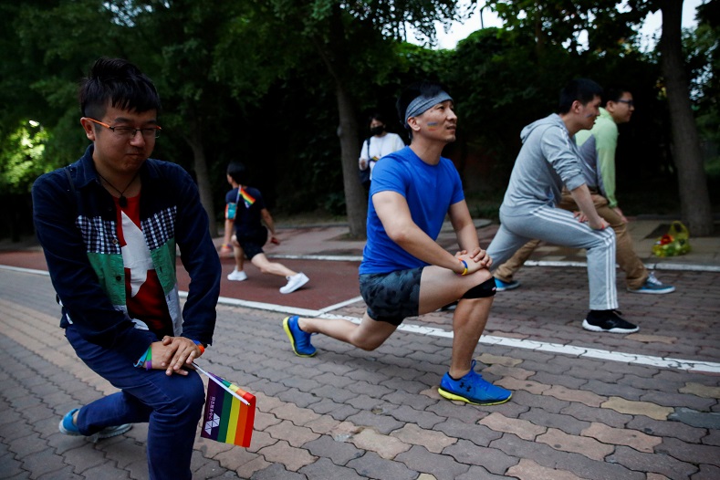 Participants warm up for a 5.17 km run to mark International Day Against Homophobia in a park in Beijing, China, May 17, 2018.
