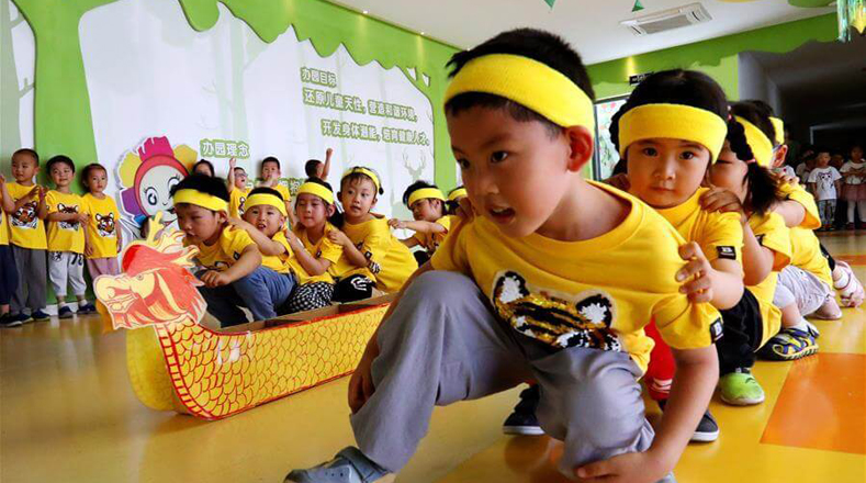 En la provincia de Suzhou, los pequeños festejan al jugar con botes de dragón realizados con materiales reciclables, como cajas y papel.