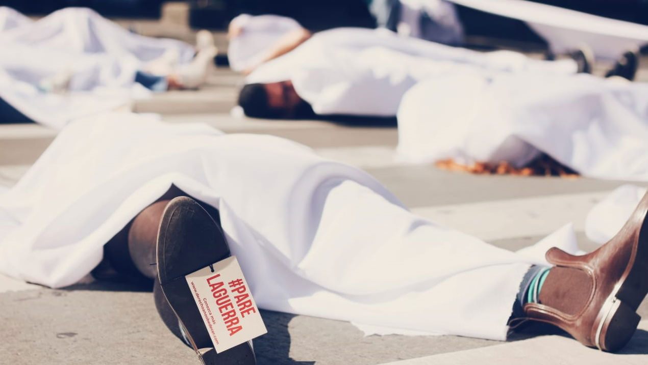 Las personas se acostaron en las calles con sábanas que le cubrían el cuerpo y etiquetas en los pies en referencia a todos los asesinatos que han ocurrido en este 2018 en Medellín.