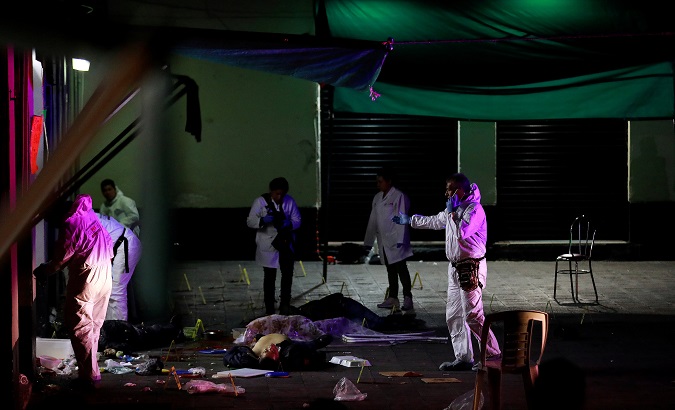 Forensic technicians work at the crime scene where three men were gunned down by unknown assailants at an intersection on the edge of tourist Plaza Garibaldi in Mexico City.