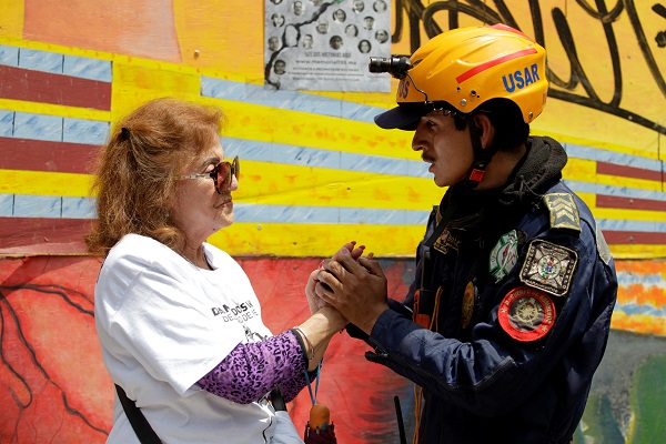 A woman thanks a rescue worker after a minute of silence at the Tlalpan housing project.