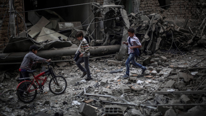 Niños observan los efectos de un bombardeo a un hospital en las afueras de Damasco en 2015. Este martes grupos ilegales atacaron 9 localidades en tres provincias sirias.