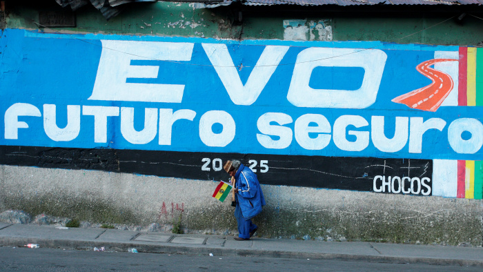 Un hombre camina junto a la pared donde se lee un eslogán a favor del presidente Evo Morales en La Paz, Bolivia.
