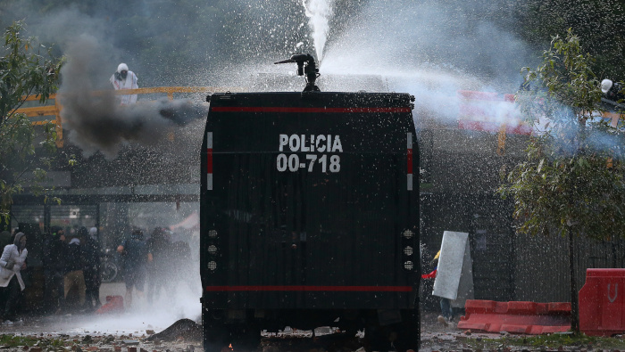 Un vehículo de la policía antidisturbios de Colombia rocía cañones de agua contra manifestantes durante una protesta en Bogotá.