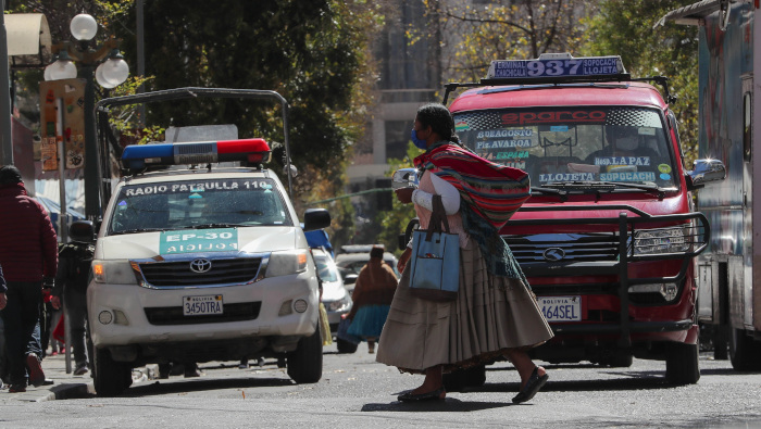 Una mujer cruza una calle este lunes en La Paz, Bolivia, en el marco de la flexibilización del confinamiento social.