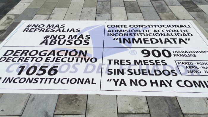 Plantones y carteles acompañan las protestas de los trabajadores frente a la empresa estatal Correos de Ecuador.