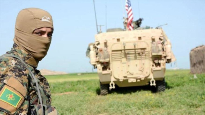 En la imagen de archivo aparece un miliciano kurdo junto a un vehículo blindado de EE.UU. en Siria.