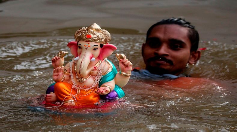 En Mumbai, un voluntario accede al paseo marítimo para sumergir a la figura de Ganesha en un estanque artificial, como parte del ritual más destacado del festival. 