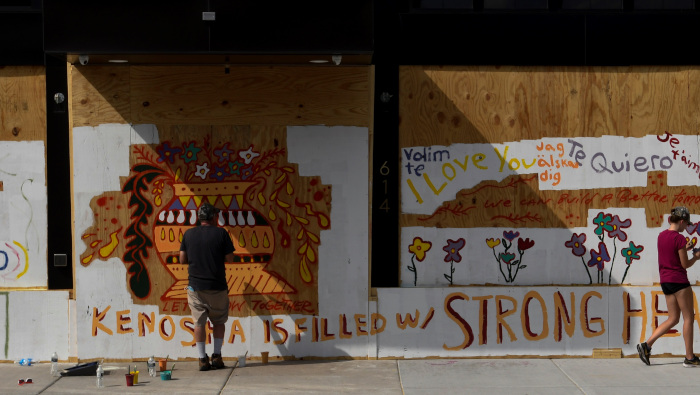 Personas pintan un mural en un edificio a raíz del tiroteo de Jacob Blake por parte de agentes de policía, en Kenosha, EE.UU.