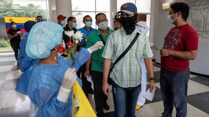 Trabajadores de la salud despiden a un grupo de personas que se recuperaron de la Covid-19 en un hotel sanitario en Caracas.