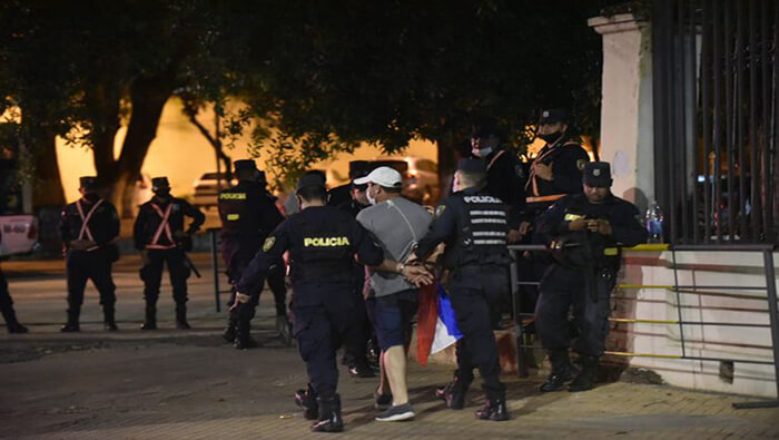 Policías trasladan a uno de los manifestantes detenidos durante la protesta frente a la residencia presidencial.