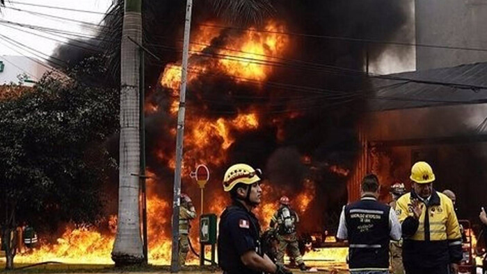 Bomberos peruanos intentan controlar el fuego desatada en el interior de un depósito de pirotécnicos en la zona capitalina de Ate Vitarte.