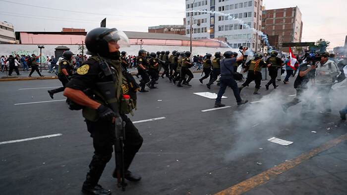 Agentes policiales lanzan bombas lacrimógenas hacia manifestantes en la capital peruana.