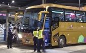 Funcionarios migratorios chinos revisan un autobús con turistas. 