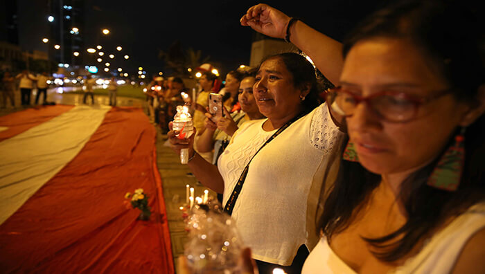 Un grupo de personas participa en una vigilia en homenaje a Rosalino Flores, frente al Palacio de Justicia en Lima, Perú.