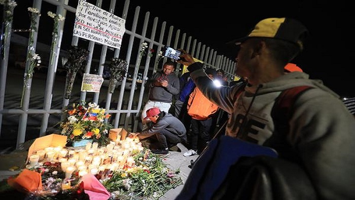 Familiares de las víctimas y otros migrantes realizan una vigilia en homenaje a los fallecidos en las afueras de la sede del Instituto Nacional de Migración en Ciudad Juárez.
